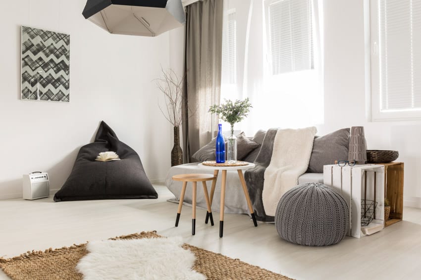 Living room with bean bag chair, couch, pouf, coffee table, pendant light, and window curtains