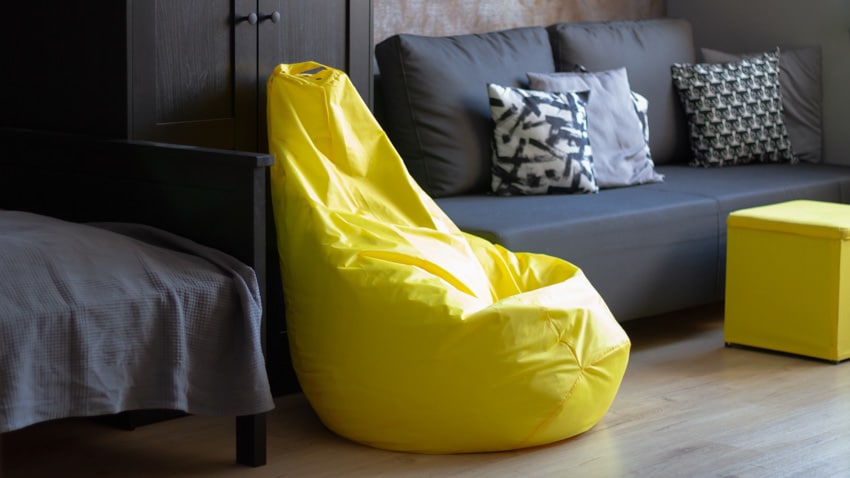 Living room with couch, wood floor, and yellow bean bag chair