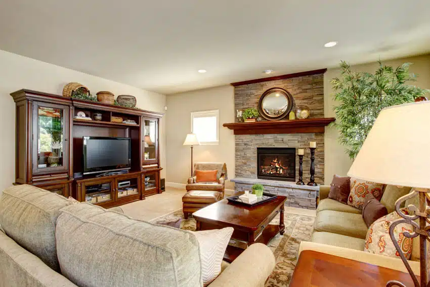 Living room with mahogany coffee table, floating shelf, TV stand, television, sofa, and floor lamp