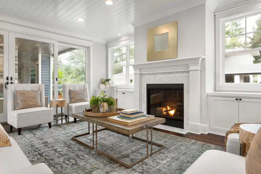 Living room with transitional furniture, coffee table, rug, fireplace, shiplap ceiling, chairs, rug, and windows