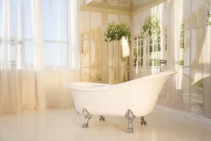 Luxury bathroom with freestanding tub, window, curtains, and aluminum clawfoot tub feet
