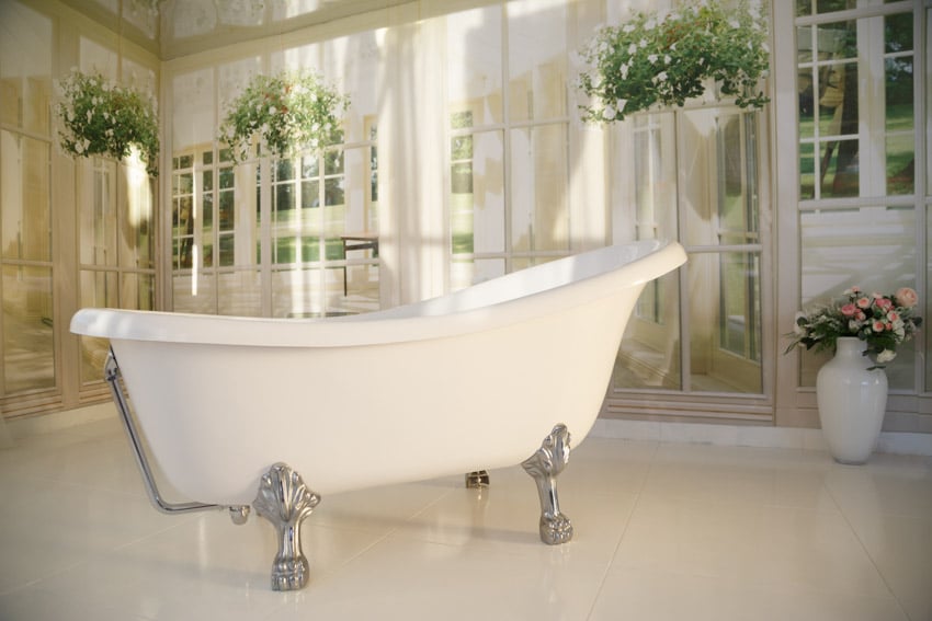 Luxury bathroom with tub, floor vase, tile flooring, indoor plants, and clawfoot tub feet