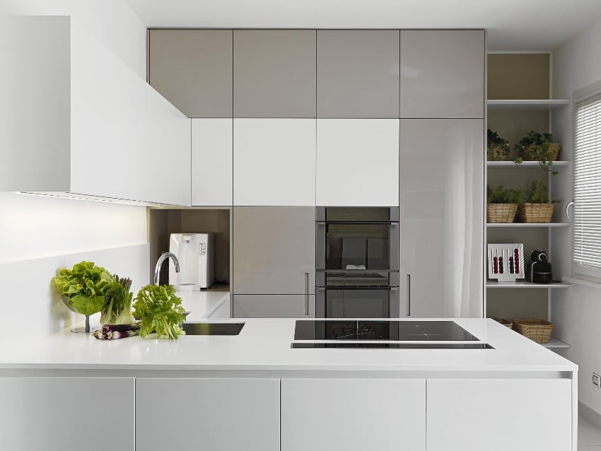 Minimalist modern fitted kitchen with vegetables on the white worktop