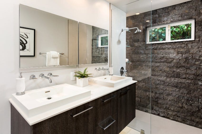Modern bathroom design with slate shower walls, mirror and floating cabinet with sinks
