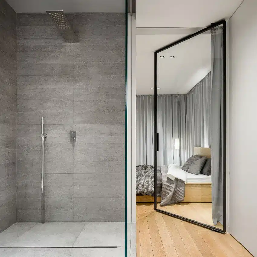 Modern bathroom with spacious walk in shower with vinyl panel walls next to elegant bedroom with glass door