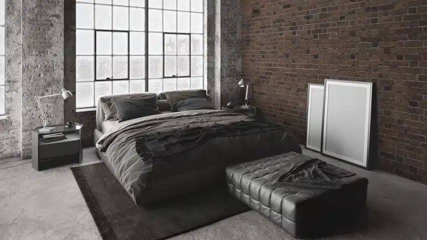 Modern industrial room with comforter, windows, nightstand, ottoman, rug, and bricks