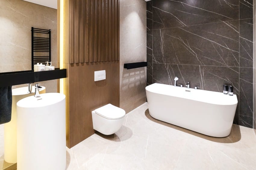 New modern bathroom with large mirror, porcelain pedestal sink and lighting