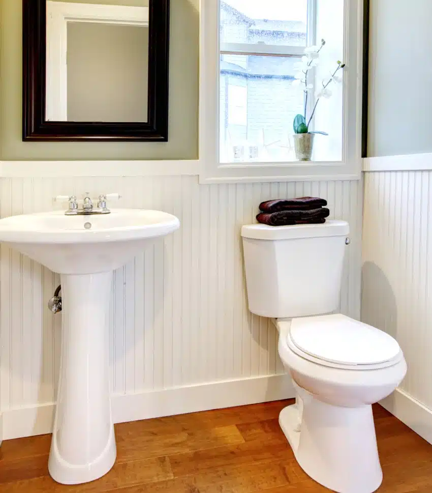 A nice small new, simple and elegant bathroom with toilet and a small pedestal sink