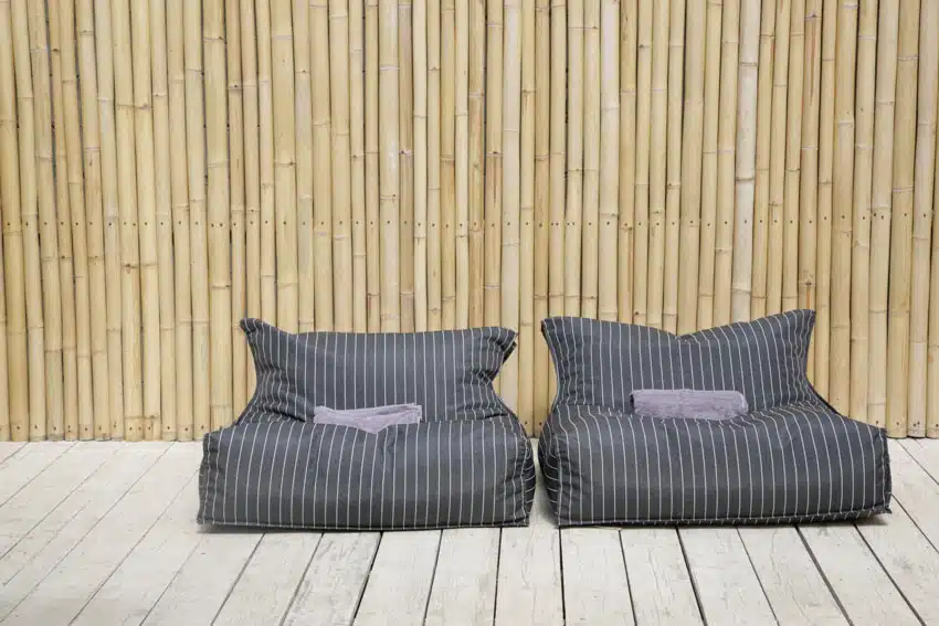 Bamboo privacy fence with wood deck and striped chair