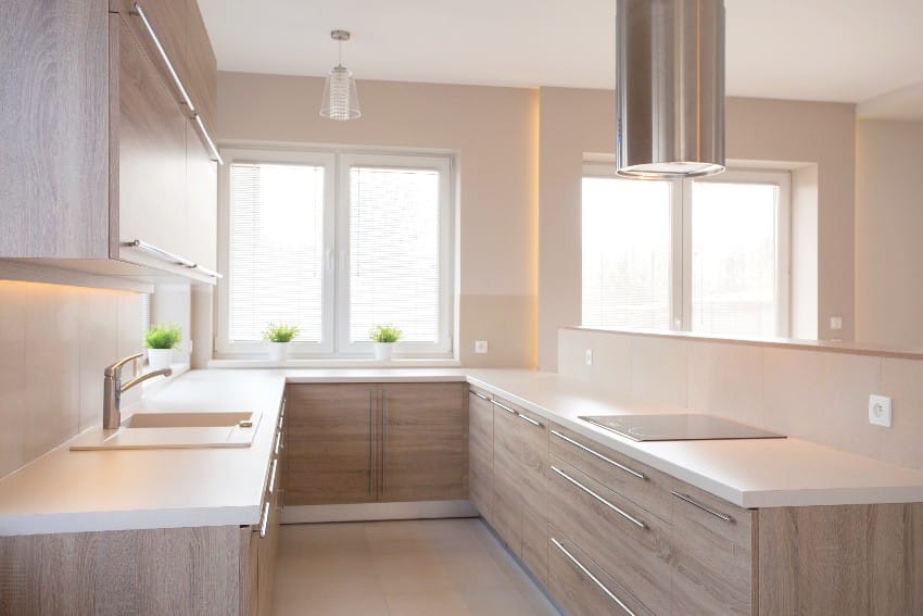 New style commodious kitchen with pale wood drawers, sliding window and faucet