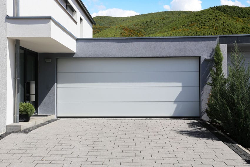 Residential garage with vertical bifold garage doors and paved driveway