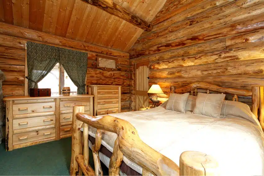 Rustic bedroom with aspen wood dresser, lamp, bed frame, mattress, pillows, window, and curtains
