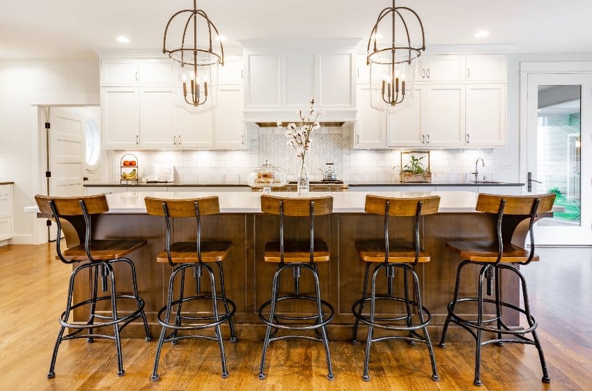 Modern Colonial craft kitchen remodel with white cabinets, wrought iron and wood chairs, eating counter and light fixtures