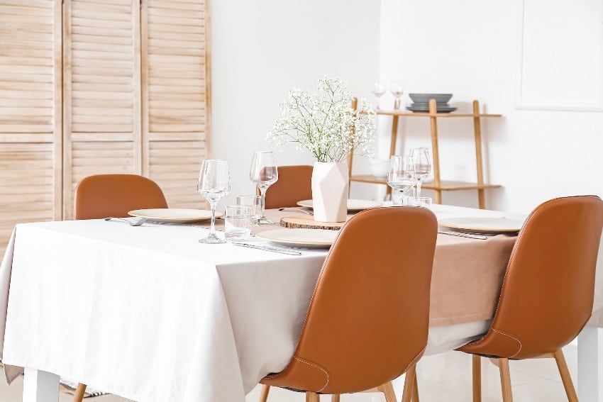 Served table with white tablecloth fabric in modern dining room
