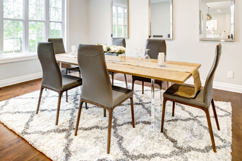 Simple minimalist dining room with solid maple wood table, hardwood floors with carpet and mirrors on wall