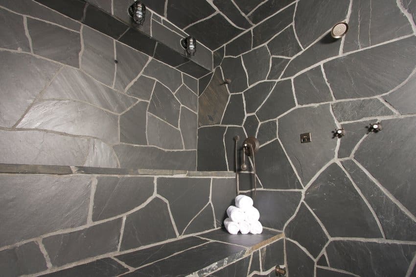 Slate shower walls and white rolled towels