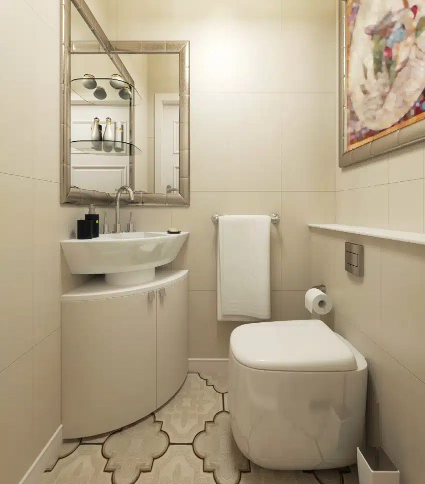 Small bathroom features corner pedestal sink with cabinet and mirror