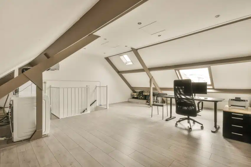 Spacious attic office with chair, filing cabinet, ceiling lights, and skylight window