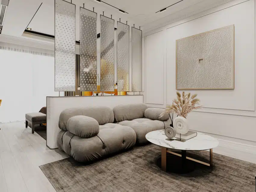 Studio apartment with custom divider, cushioned sofa, small round coffee table, and floor rug