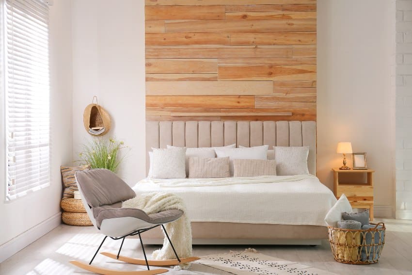 Stylish room interior with stacked alder wood and big comfortable bed