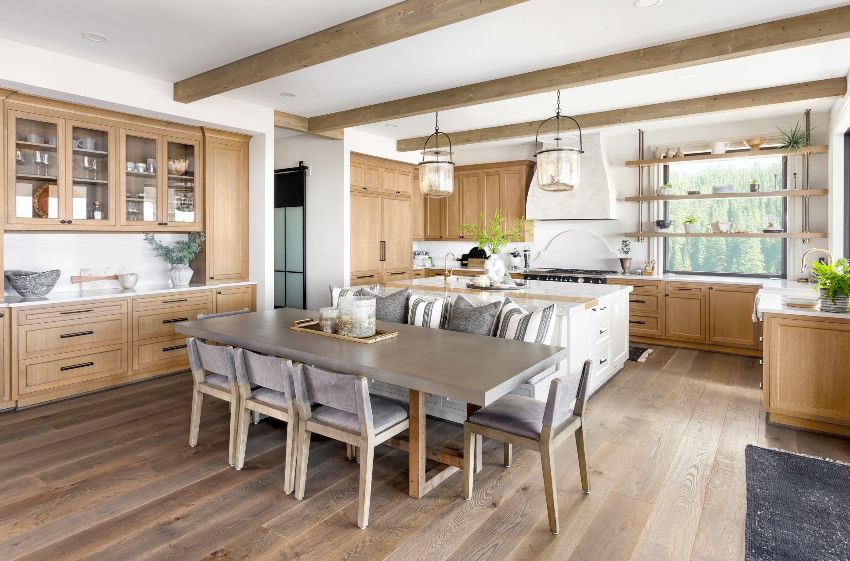Traditional kitchen in new luxury home with hardwood floors, colonial kitchen cabinets, wood beams, large island, quartz counters and dining set