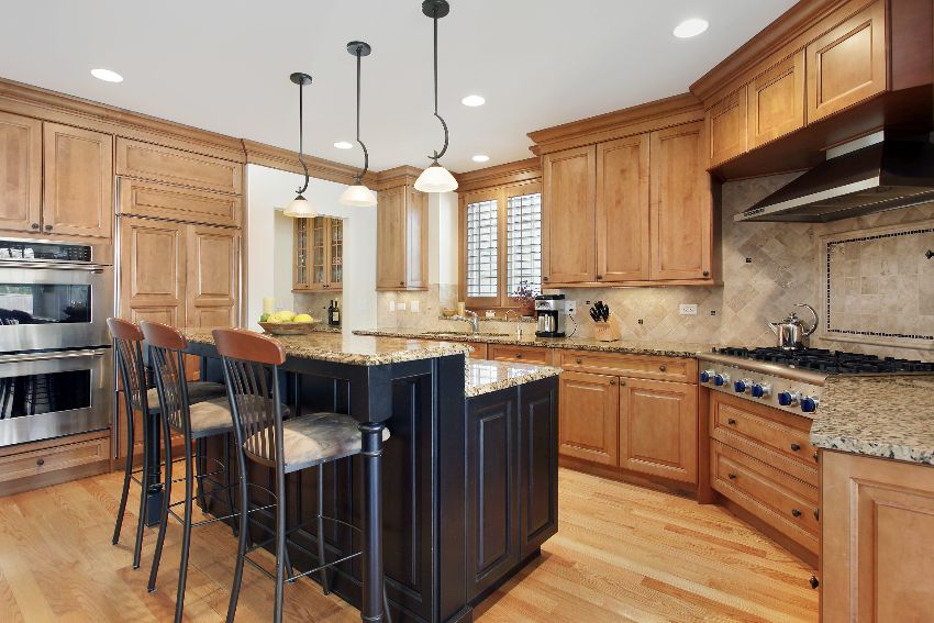Traditional kitchen with granite island and green alder wood cabinetry