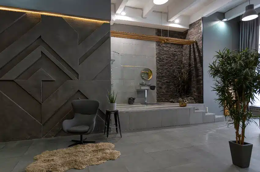 Trendy interior design of an open plan apartment with an open shower with gray slate designs
