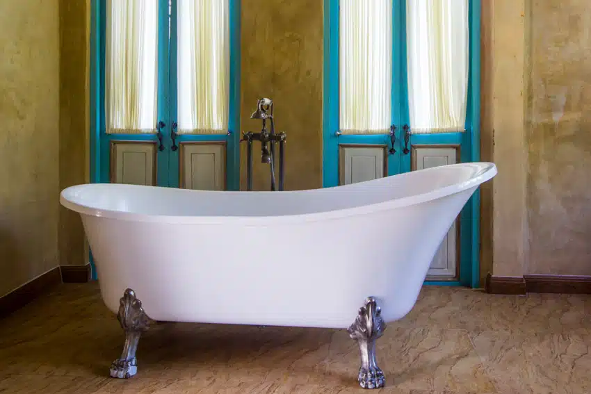 Vintage bathroom with freestanding tub, windows, curtains, and brushed nickel clawfoot tub feet