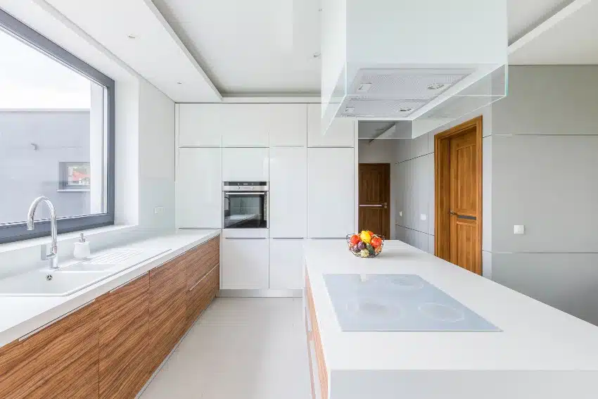 Kitchen with white walls, long island and wooden doors