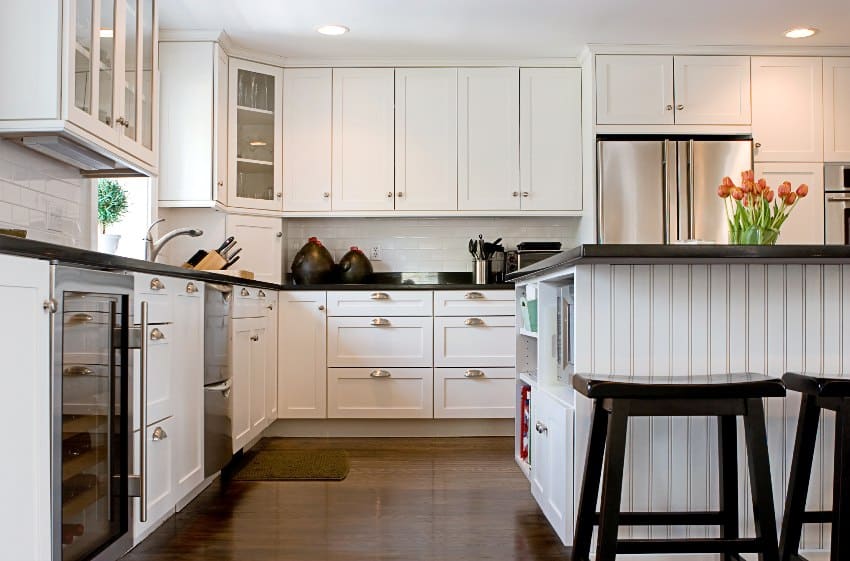 White traditional kitchen with colonial kitchen cabinets, island and granite counters