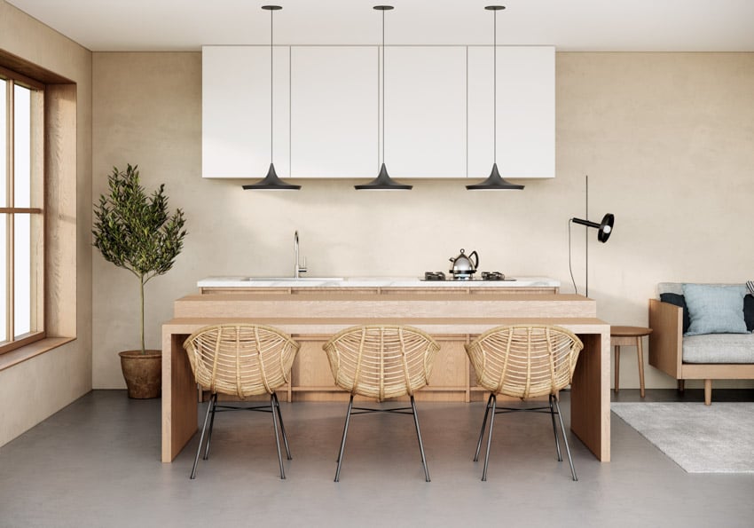 Japandi kitchen with chairs, wood peninsula, white cabinets, and black pendant lights