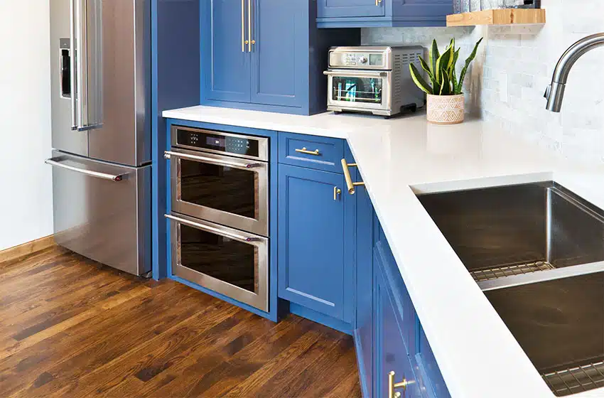 Kitchen with blue cabinets wood flooring double oven double sink