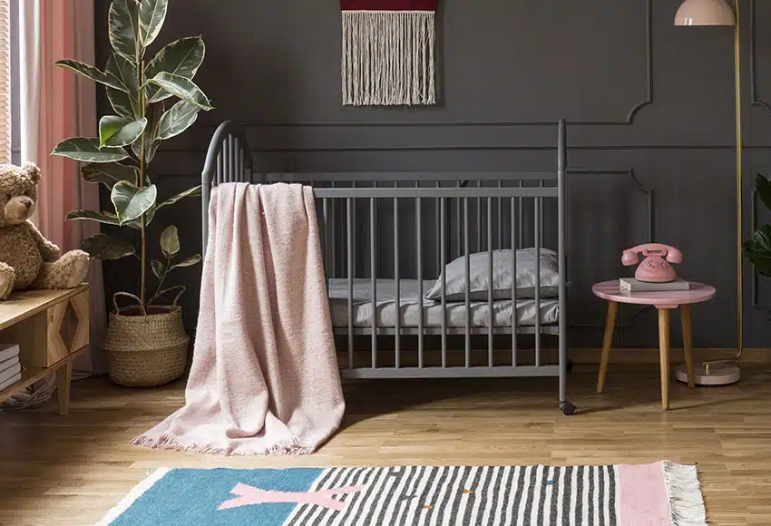 Nursery room with steel crib gray coffee table