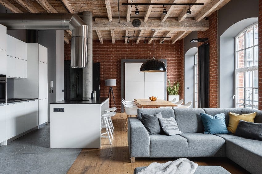 Industrial style farmhouse living room interior features brick on the wall and wooden ceiling