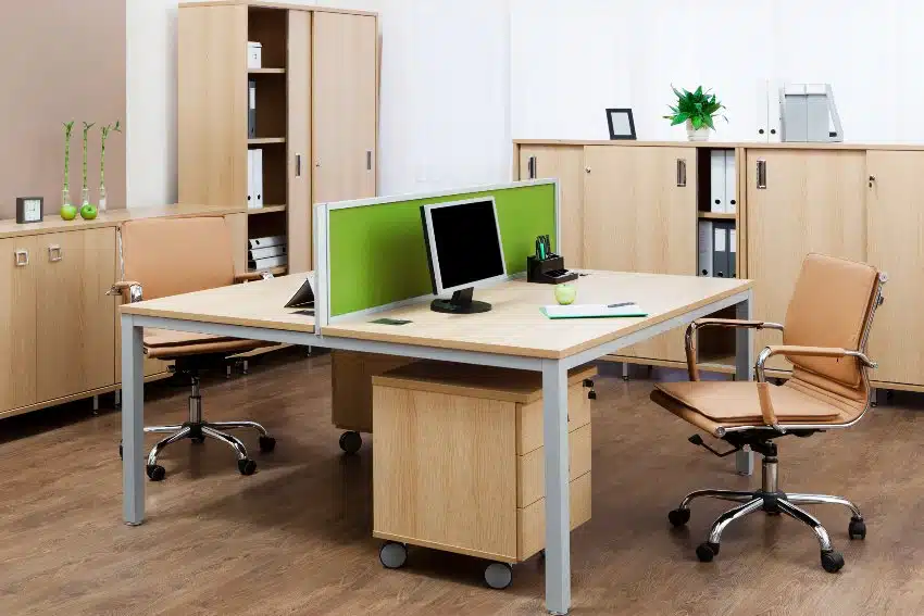 Armchairs, file cabinets and monitor on a secretary desk in a modern office