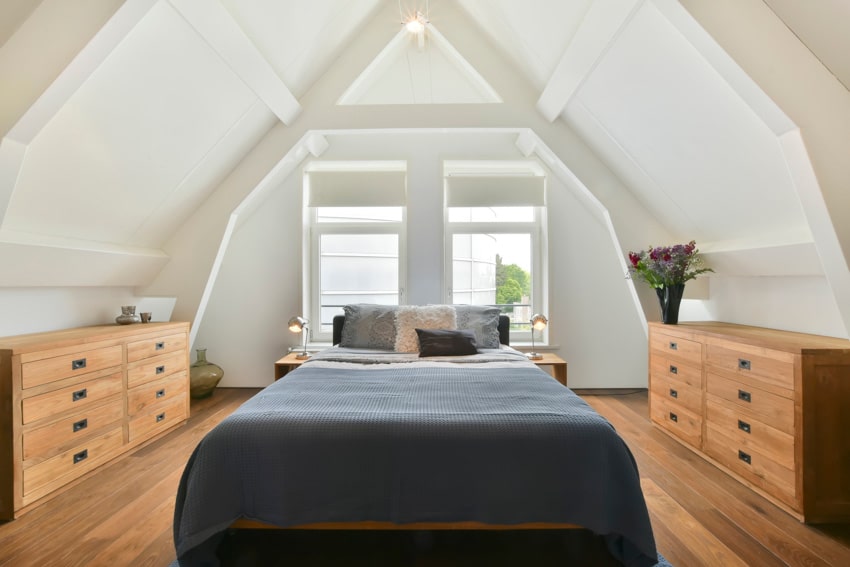 Attic bedroom with mattress, dressers and bed with blue covers