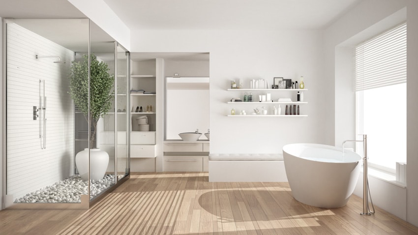 Bathroom with Corian shower wall, wood flooring, tub, floating shelves, and indoor plant