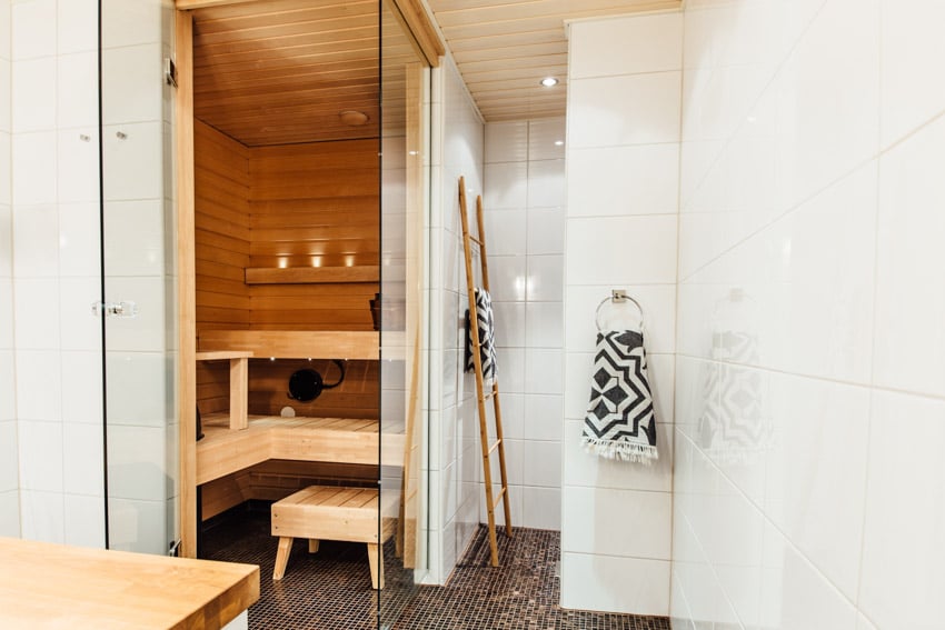 Bathroom with shower dry sauna combo, tile walls, mosaic tile flooring, and seating