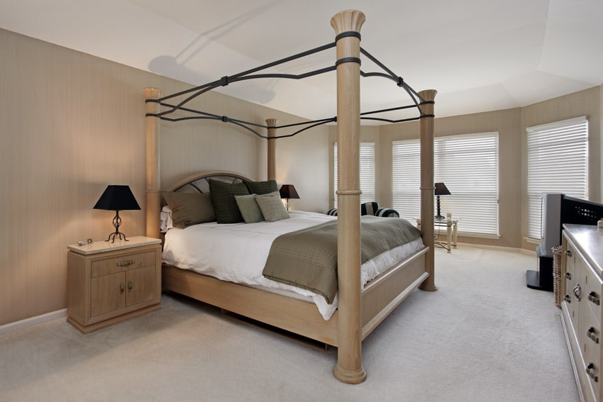 Bedroom with unfinished oak nightstands, four poster bed frame, mattress, pillows, windows, and lamps