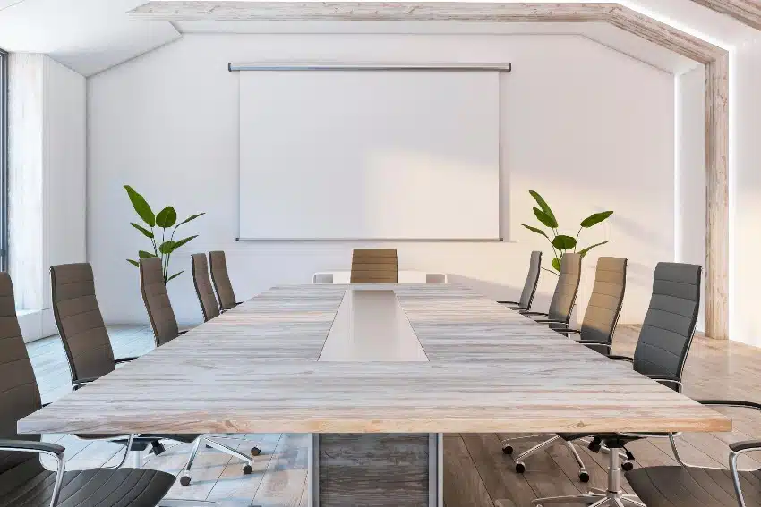 Bright concrete and wooden conference room interior with empty white mock up poster, armchairs and conference table