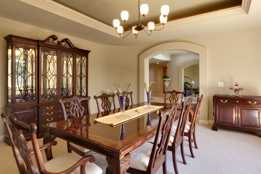 Classic dining room with natural cherry wood table, chairs, glass cabinet, buffet table, and chandelier