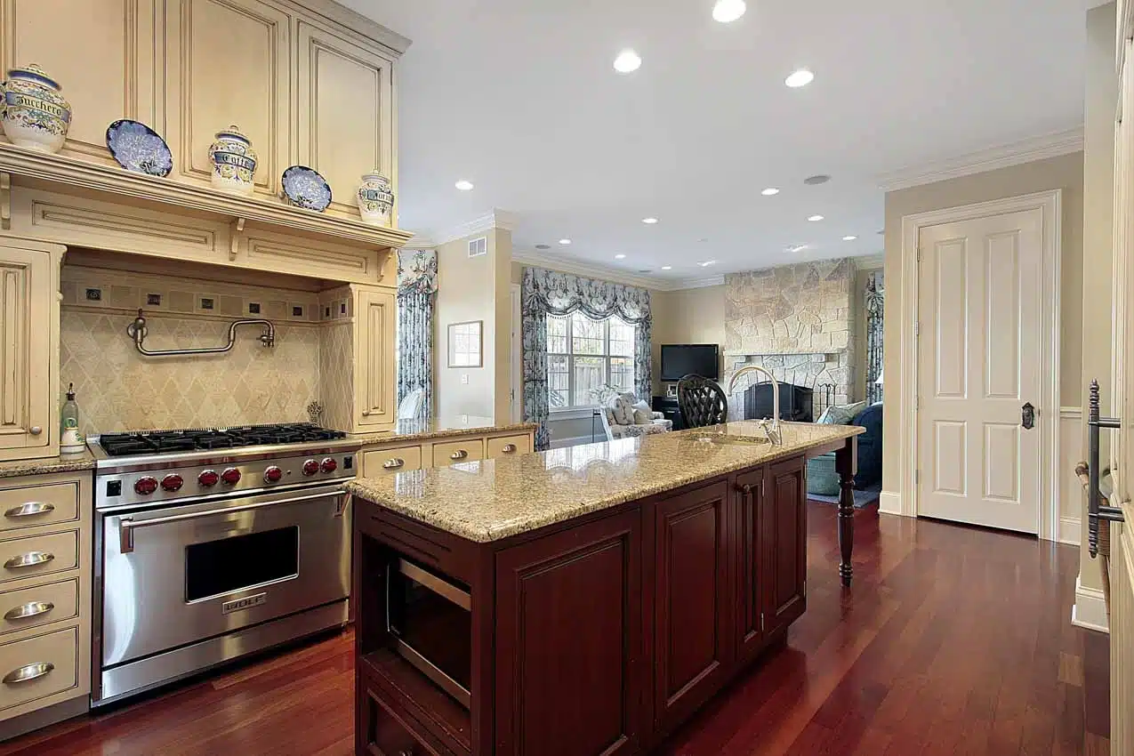 Classic kitchen with Santa Cecilia granite countertop, island, and wood flooring