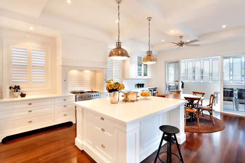 Kitchen with island, countertops, pendant lights, table, chairs, bar stool, shutter and windows