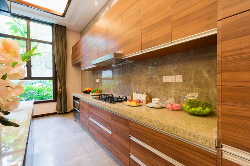 Contemporary kitchen with granite countertop, backsplash, stove, range hood, window, wood cabinets, and curtains
