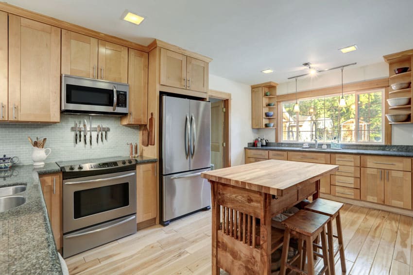 Craftsman kitchen with island bar, stools, teak countertop, wooden cabinets, stove, oven, refrigerator, and windows