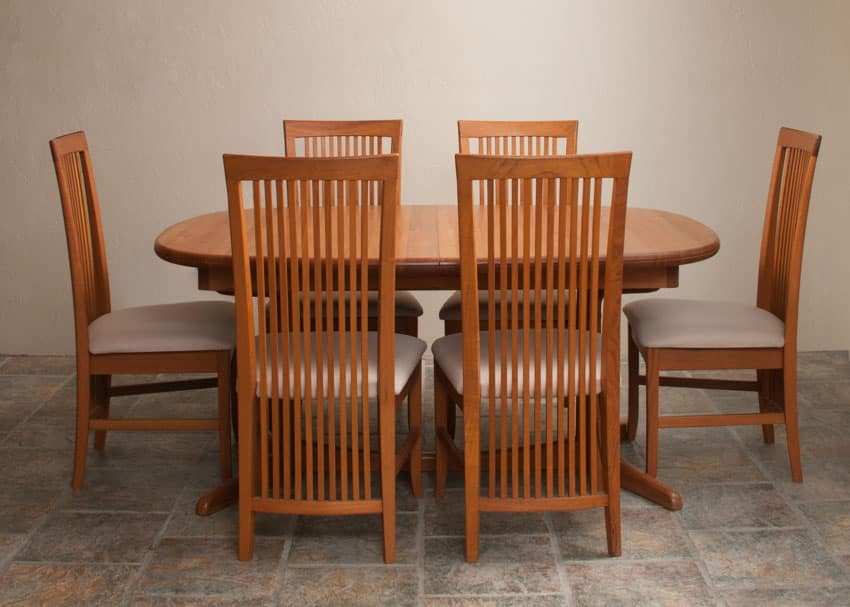 Dining room with Frank Lloyd style chairs made of cherry wood, table, and tile floors