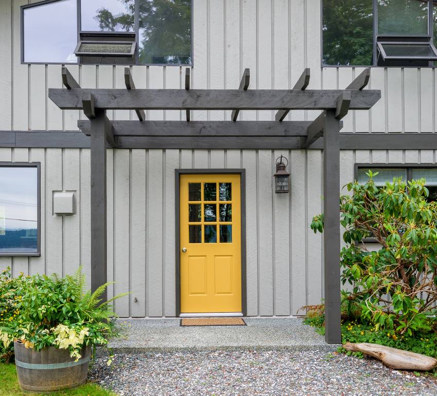 Entrance of a gray modern cottage house with yellow door