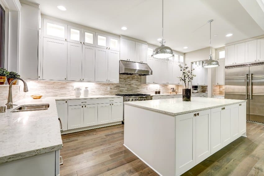 Gourmet kitchen with RTF cabinets, marble countertops, stone subway tile backsplash, refrigerator, and kitchen island