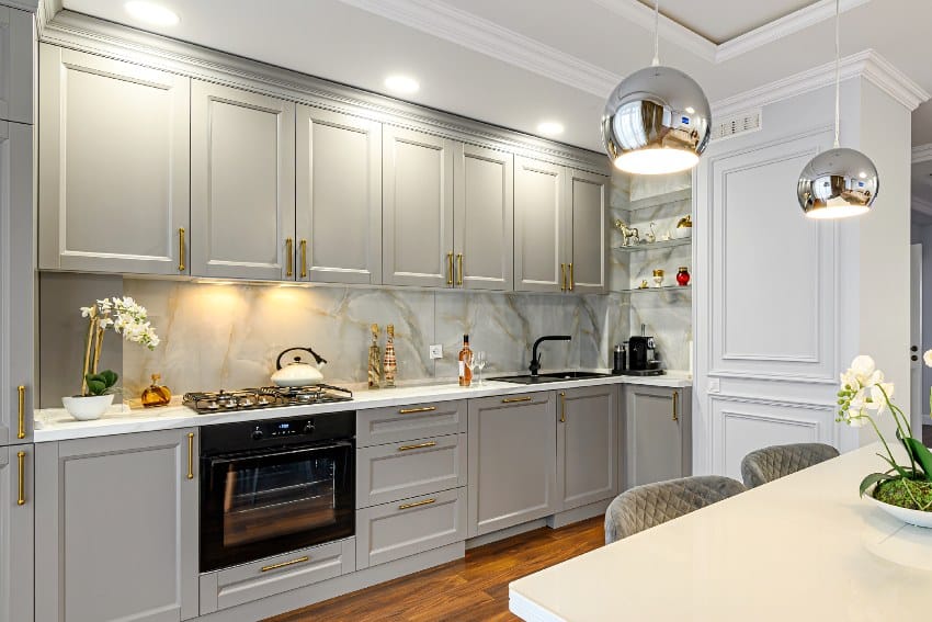 Grey and white contemporary kitchen interior with RTF cabinets, gold door handles, and marble backsplash