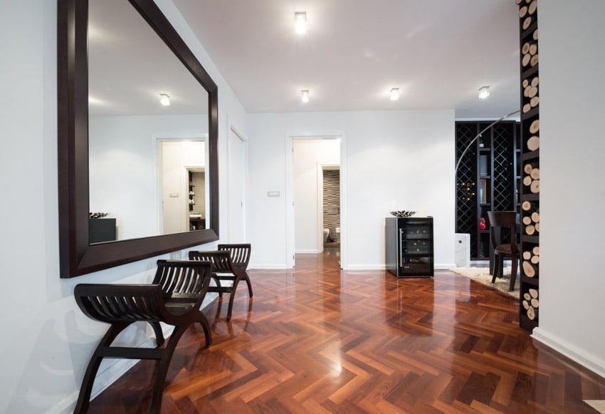 House with large wall mirror, accent wood chairs, and glossy finished floors